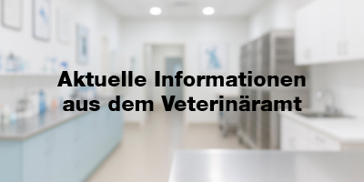 Unscharfe Innenaufnahme eines Labors mit OP-Tisch, Käfigen und medizinischer Ausstattung. Im Vordergrund steht in schwarzer Fettschrift: „Aktuelle Informationen aus dem Veterinäramt“.