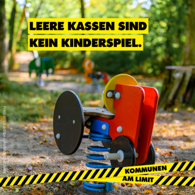 Ein verlassenes Spielplatzgerät steht auf einem verschwommenen Spielplatz. Oben steht in großen schwarzen Buchstaben auf gelbem Grund: „Leere Kassen sind kein Kinderspiel.“ Unten verläuft ein schwarz-gelbes Absperrband mit der Aufschrift „Kommunen am Limit“.