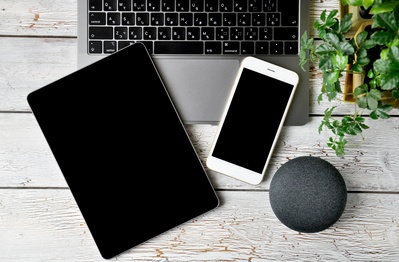 Auf dem Bild ist ein Laptop, Mobiltelefon u Alexa abgebildet.