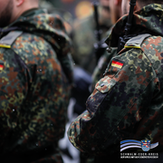 Das Bild zeigt mehrere Soldaten der Bundeswehr in Flecktarn-Uniformen. Gut sichtbar ist das Deutschlandabzeichen an den Ärmeln. Die Soldaten stehen dicht beieinander, vermutlich in Formation oder während eines Appells. Im rechten unteren Bildbereich ist das Logo des Schwalm-Eder-Kreises mit dem Slogan „Der Kreis mit den schönsten Ecken“ eingeblendet.