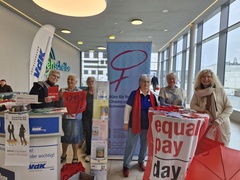 Das Bild zeigt Frauen die anlässlich des Equal Pay Days an einem Informationsstand stehen