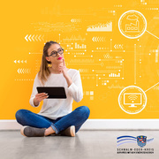 Eine junge Frau mit langen, braunen Haaren sitzt im Schneidersitz auf einem grauen Boden vor einer leuchtend gelben Wand. Sie trägt eine runde schwarze Brille, ein weißes Langarmshirt, blaue Jeans und graue Sneakers. In ihrer linken Hand hält sie ein schwarzes Tablet, während sie mit dem rechten Zeigefinger nachdenklich ihr Kinn berührt und leicht zur Seite blickt – als ob sie über etwas nachdenkt. Im Hintergrund sind viele weiße, grafische Elemente zu sehen, die an digitale Netzwerke, Datenanalysen und Industrie 4.0 erinnern: Diagramme, Verbindungslinien, Kreise mit Symbolen wie einer Fabrik und einem Monitor mit WLAN-Symbol. Die Gestaltung vermittelt ein Gefühl von Technologie, Digitalisierung und Innovation. Unten rechts befindet sich das Wappen und Logo des „Schwalm-Eder-Kreises“ mit dem Slogan: „Der Kreis mit den schönsten Ecken“. 