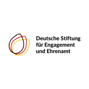 Auf hellem Hintergrund ist das Logo der „Deutschen Stiftung für Engagement und Ehrenamt“ zu sehen. Links befinden sich drei überlappende, tropfenförmige Linien in Schwarz, Rot und Gelb. Rechts daneben steht der Name der Stiftung in schwarzer Schrift.