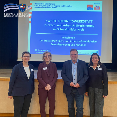 Gruppenfoto vor einer Leinwand mit Veranstaltungsfolie zur „Zweiten Zukunftswerkstatt zur Fach- und Arbeitskräftesicherung im Schwalm-Eder-Kreis“ am 29. September 2025 in Homberg (Efze). Abgebildet sind (v. l.): Dr. Christa Larsen (Institut für Wirtschaft, Arbeit und Kultur – IWAK), Claudia Wesner (Stabsstelle Fachkräfte für Hessen im Hessischen Ministerium für Arbeit, Integration, Jugend und Soziales), Landrat Winfried Becker und Tatjana Grau-Becker, Wirtschaftsförderin des Schwalm-Eder-Kreises.
